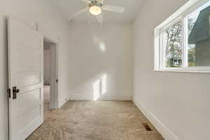 Unfurnished room with ceiling fan and light colored carpet