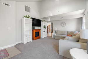 Carpeted living room featuring a high ceiling