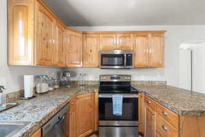 Kitchen featuring light stone countertops and stainless steel appliances