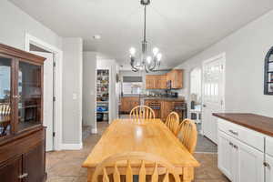 Tiled dining space featuring a chandelier