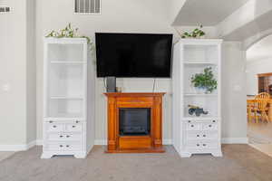 Living room with built in shelves and light colored carpet