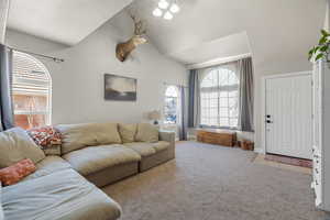 Living room featuring a textured ceiling, light carpet, and vaulted ceiling