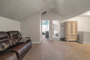 Living room with light colored carpet and vaulted ceiling