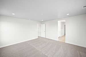 Empty room featuring light colored carpet