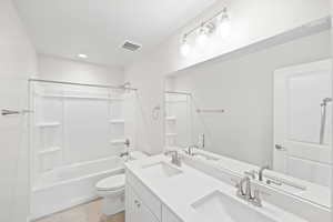 Full bathroom featuring tile patterned flooring, vanity, toilet, and shower / tub combination