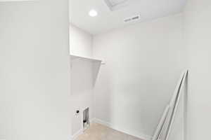 Washroom featuring electric dryer hookup and light tile patterned floors