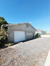 View of property exterior with a garage and an outdoor structure