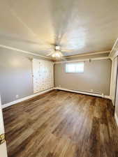 Unfurnished bedroom featuring a textured ceiling, ceiling fan, wood-type flooring, a baseboard radiator, and a closet