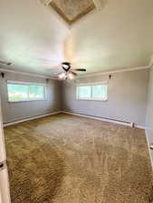 Spare room with carpet, plenty of natural light, ceiling fan, and ornamental molding