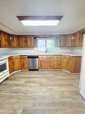 Kitchen featuring decorative backsplash, light hardwood / wood-style flooring, white appliances, and sink