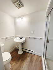 Bathroom with walk in shower, wood-type flooring, and toilet