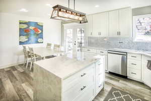 Kitchen view 3 into dining area featuring french doors to patio. with pendant lighting, dishwasher, a center island, white cabinets