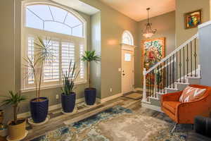 Foyer entrance and living room featuring beautiful lvp floors, box window and plantation shutters