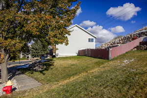 View of yard from side showing fencing, and terrace