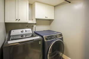 Laundry area featuring  over appliance and LVP floors cabinets