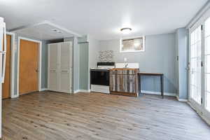 Kitchen featuring white range with electric stovetop, tasteful backsplash, plenty of natural light, and light hardwood / wood-style floors