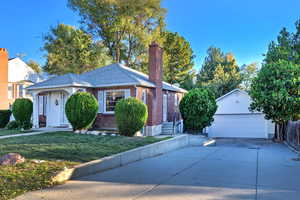 View of front of property with a garage, an outbuilding, and a front yard