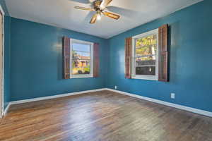 Unfurnished room with a wealth of natural light, hardwood / wood-style floors, and ceiling fan