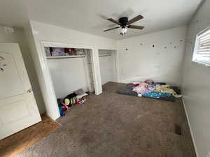 Unfurnished bedroom featuring multiple closets, ceiling fan, and carpet floors