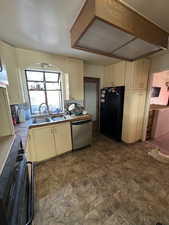 Kitchen with dishwasher, black fridge, and sink