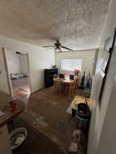 Dining space with a textured ceiling, ceiling fan, and dark hardwood / wood-style floors