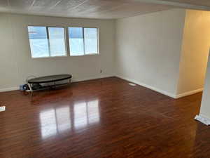 Empty room featuring dark hardwood / wood-style floors