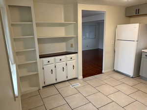 Kitchen featuring gray cabinets, white fridge, and light hardwood / wood-style floors