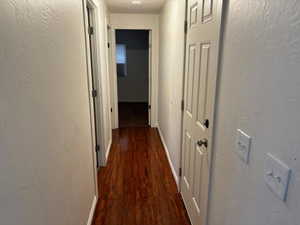 Hallway with dark hardwood / wood-style floors