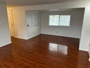 Empty room with dark hardwood / wood-style floors