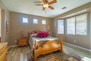 Bedroom with ceiling fan, light hardwood / wood-style flooring, and a textured ceiling