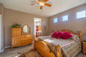 Bedroom featuring ceiling fan, wood-type flooring, and connected bathroom