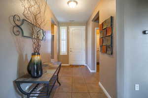 Doorway to outside featuring tile patterned flooring and a textured ceiling