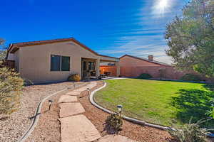 Rear view of property featuring a lawn and a patio area