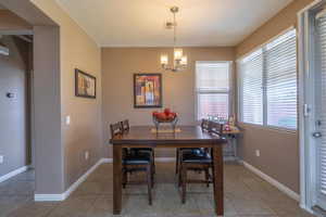 Dining area with tile patterned flooring and a chandelier