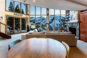 Carpeted living room featuring a mountain view, a fireplace, and a towering ceiling