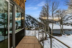 Snow covered back of property with a mountain view