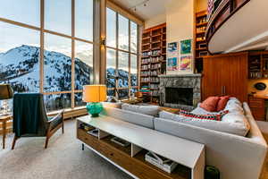 Living room with a stone fireplace, a mountain view, and carpet floors