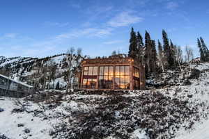 Snow covered house with a mountain view