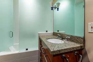 Bathroom with vanity and tiled shower / bath combo