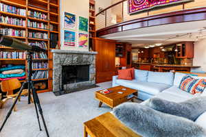 Living room featuring a stone fireplace and light carpet