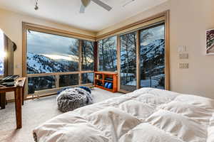 Carpeted bedroom with access to outside, a mountain view, and ceiling fan