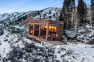 Snow covered back of property featuring a mountain view