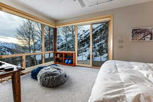 Bedroom with carpet flooring, ceiling fan, access to exterior, and a mountain view