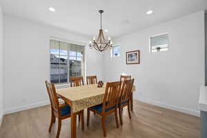 Dining area featuring light hardwood / wood-style floors and an inviting chandelier