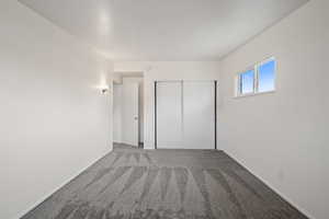 Unfurnished bedroom featuring light colored carpet and a closet