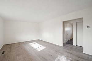 Spare room featuring a textured ceiling and light wood-type flooring