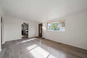 Interior space with hardwood / wood-style flooring, ceiling fan, a textured ceiling, and heating unit