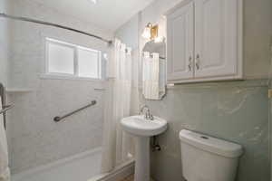 Bathroom with curtained shower and toilet