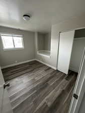 Unfurnished bedroom with a closet and dark hardwood / wood-style flooring