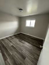 Empty room featuring dark wood-type flooring